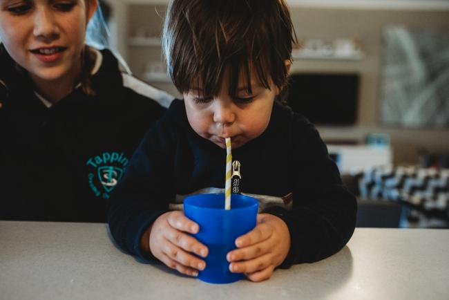 Close up of little boy drinking through a straw with Perth family photographer