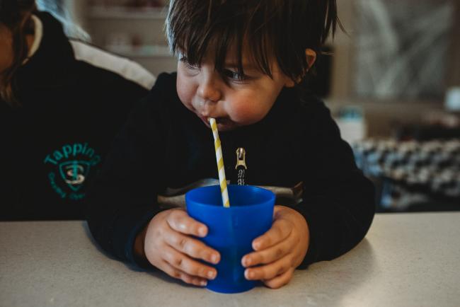Close up of little boy drinking through a straw with Perth family photographer