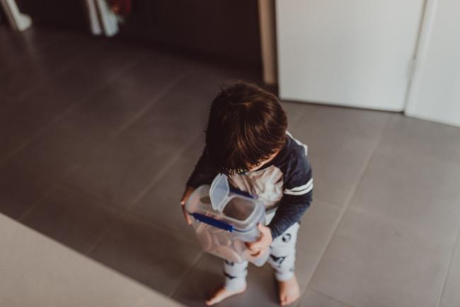 Top down image of little boy holding a container of biscuits with Family photographer Perth