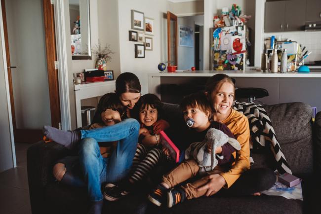 Mother sitting on the couch with her four kids with Family Photographer Perth