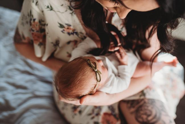 Top down image of mother holding her new baby during a Newborn lifestyle photographer Perth session
