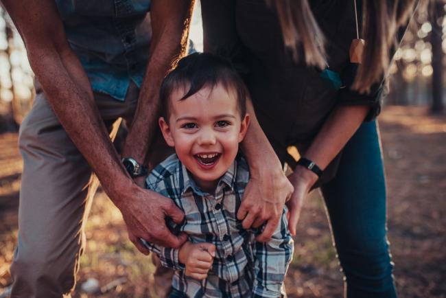 Parents tickling their little boy during a Perth maternity photography session at The Pines at golden hour