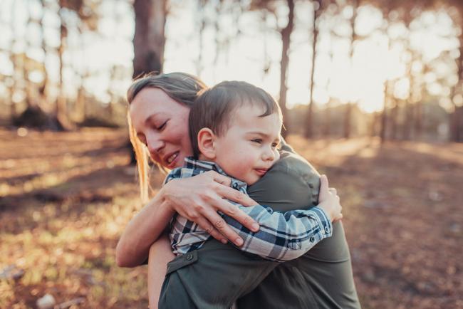 Mother and son hugging during a Perth maternity photography session at The Pines at golden hour