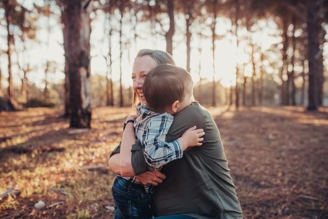 Mother and son hugging during a Perth maternity photography session at The Pines at golden hour