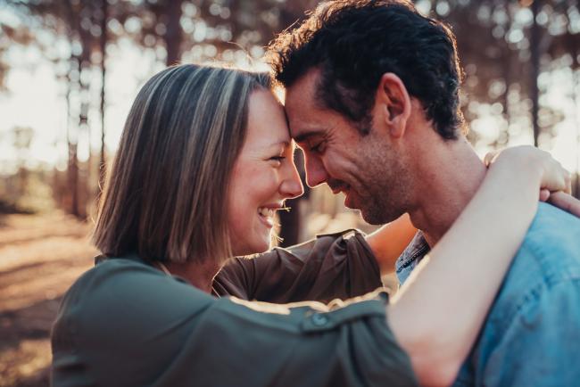 Couple laughing and touching foreheads during a Perth maternity photography session at The Pines at golden hour