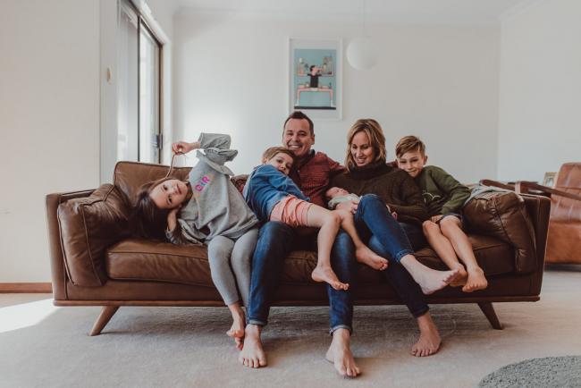 Family of 6 sitting on the couch during a Newborn Lifestyle photography session in Perth