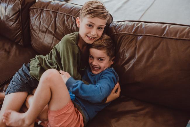 Newborn-Lifestyle-Photographer-Perth-16-of-54 Two boys hugging on the couch during a lifestyle newborn photography session in Perth