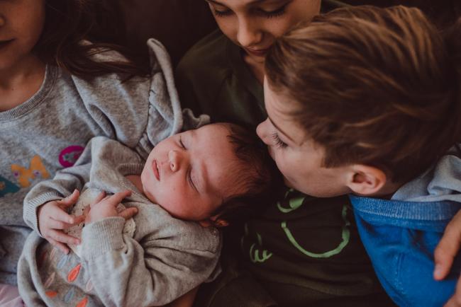Little boy kissing his baby sister during a Newborn Lifestyle photography session in Perth