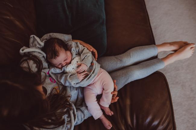Newborn-Lifestyle-Photographer-Perth-21-of-54 Top down image of little girl holding her baby sister during a lifestyle newborn photography session in Perth
