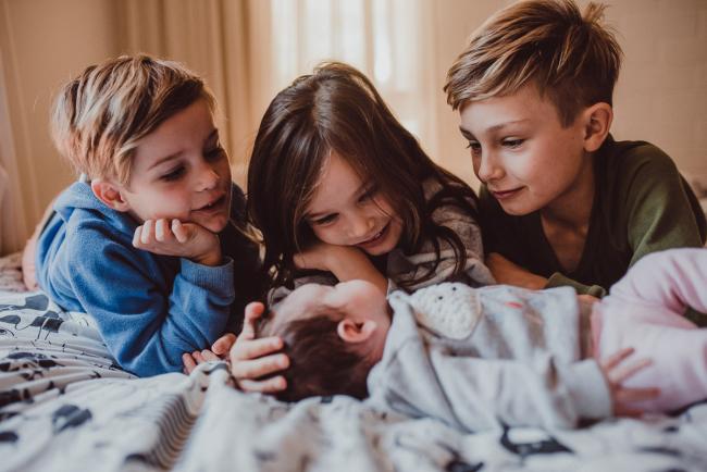 Newborn-Lifestyle-Photographer-Perth-35-of-54 Close up of siblings looking at their baby sister during a lifestyle newborn photography session in Perth