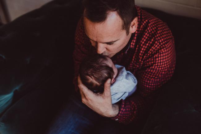 Newborn-Lifestyle-Photographer-Perth-39-of-54 Father kissing his new baby's head during a lifestyle newborn photography session in Perth