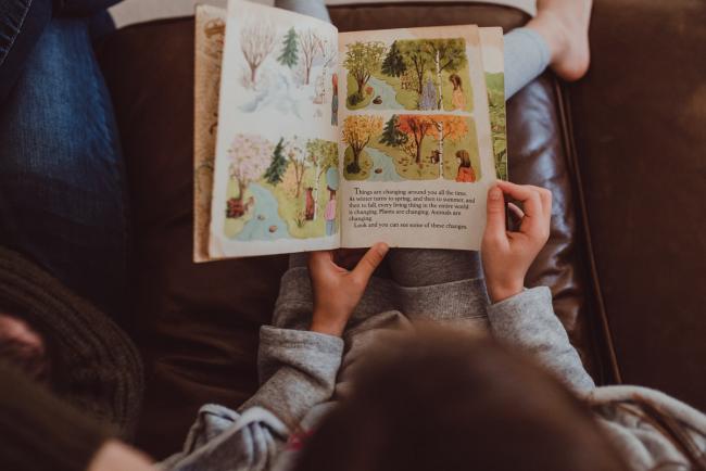 Newborn-Lifestyle-Photographer-Perth-4-of-54 Top down image of little girl reading a book during a lifestyle newborn photography session in Perth