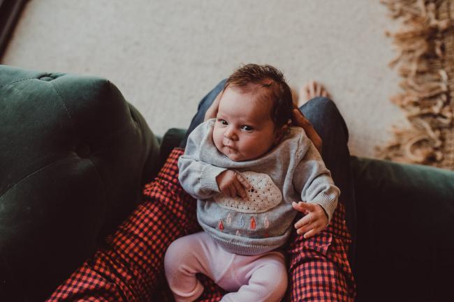 Newborn-Lifestyle-Photographer-Perth-41-of-54 Baby laying on her father's lap during a lifestyle newborn photography session in Perth