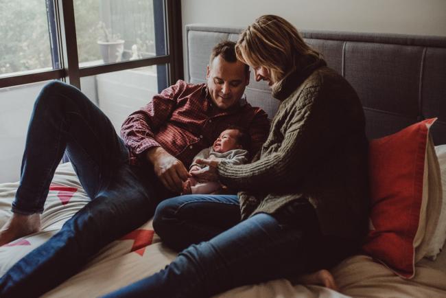 Newborn-Lifestyle-Photographer-Perth-44-of-54 Parents sitting on the bed with their new baby during a lifestyle newborn photography session in Perth