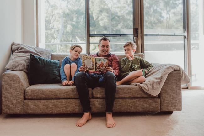 Newborn-Lifestyle-Photographer-Perth-6-of-54 Father reading a book to his two sons on the couch during a lifestyle newborn photography session in Perth