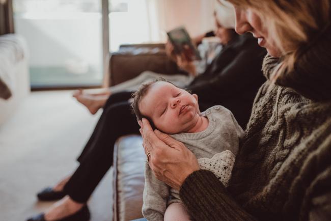 Newborn-Lifestyle-Photographer-Perth-9-of-54 Mother holding her newborn baby's face during a lifestyle newborn photography session in Perth