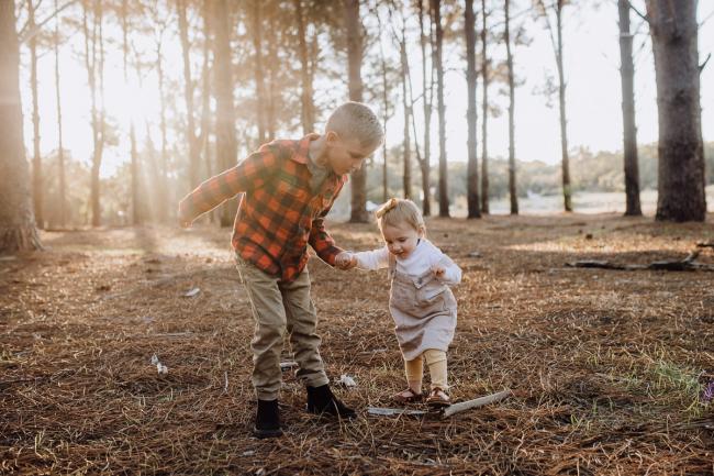 The-Pines-Family-Photographer-Perth-17-of-60 Big brother holding his little sisters hand during a Perth Family Photography session during Golden Hour at The Pines