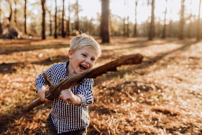 The-Pines-Family-Photographer-Perth-27-of-60 Little boy playing with a stick during a Perth Family Photography session during Golden Hour at The Pines