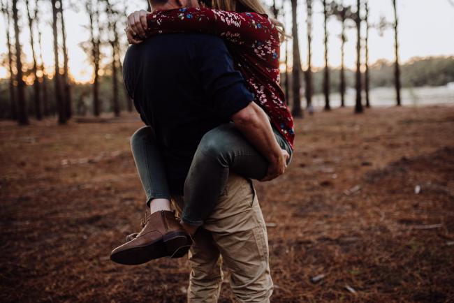 Wife's legs wrapped around her husband's waist during a couple photography session in Perth during Golden hour at The Pines