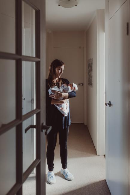 Mother standing in the doorway with her new baby with Perth lifestyle newborn photographer