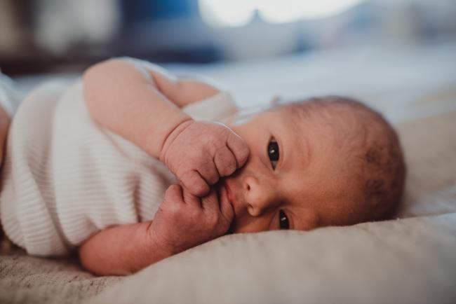 Close up of baby fists in his mouth during a Perth Fresh 48 photography session captured in home