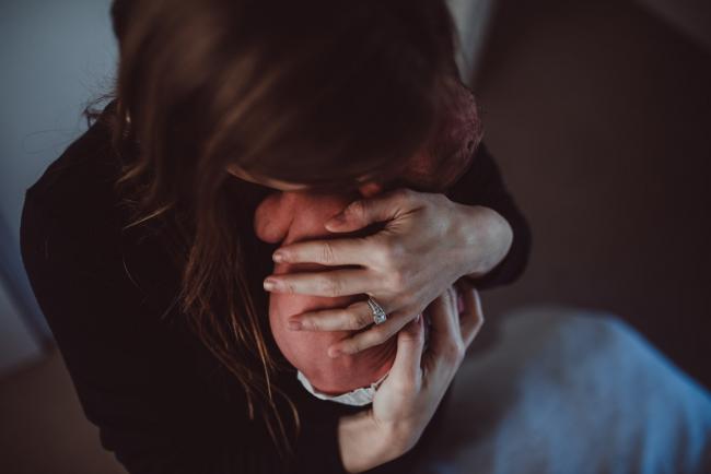 Top down image of mother's hand on new baby bare back during a Perth Fresh 48 photography session captured in home