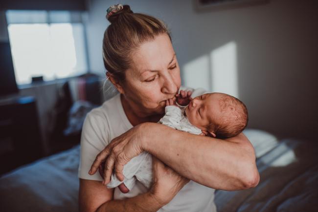 Grandmother kissing new grandson with Perth lifestyle newborn photographer