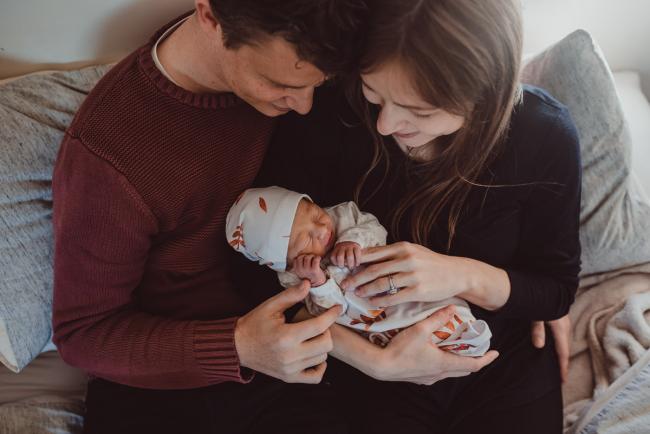 Top down image of parents holding new baby with Perth lifestyle newborn photographer