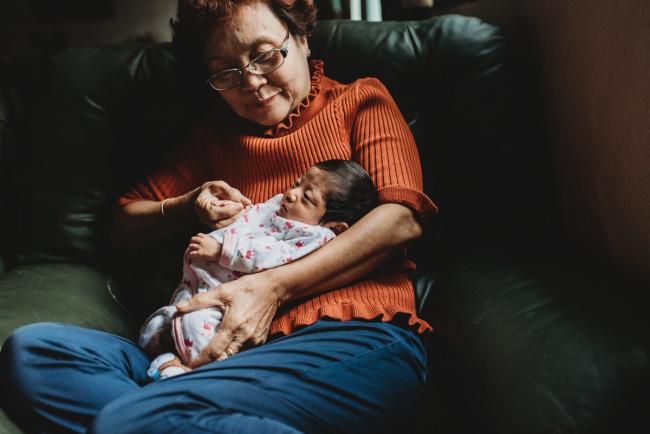 Grandmother holding her new baby granddaughter during an in-home Perth Newborn Lifestyle photography session
