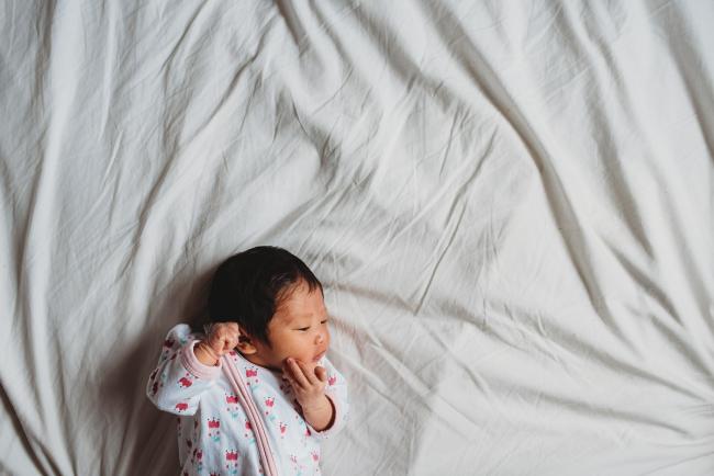 New baby laying on sheets during an in-home Perth Newborn Lifestyle photography session