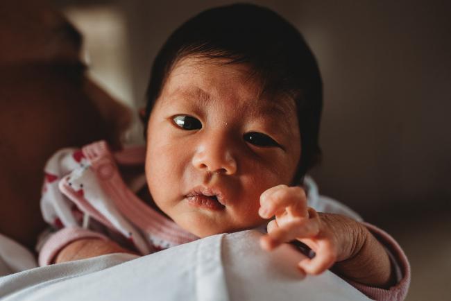 New baby looking over her father's shoulder during an in-home Perth Newborn Lifestyle photography session