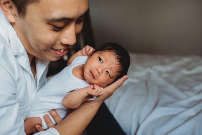 Father smiling at his new baby during an in-home Perth Newborn Lifestyle photography session