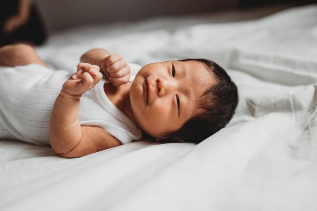 New baby laying on the bed during an in-home Perth Newborn Lifestyle photography session