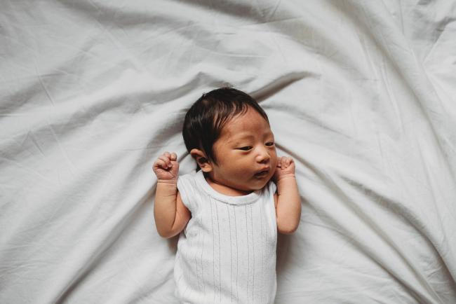 New baby laying on the bed during an in-home Perth Newborn Lifestyle photography session