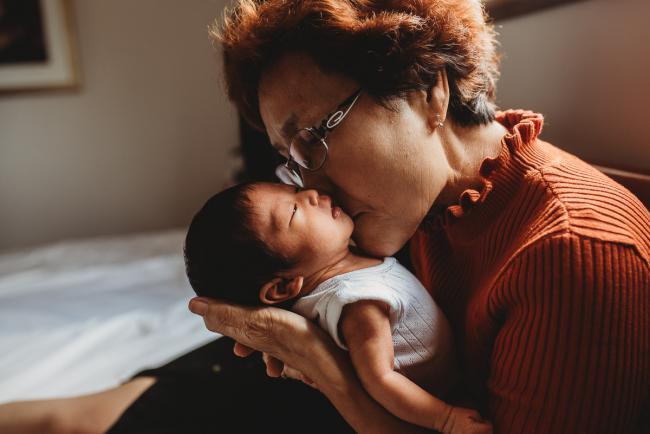 Grandmother kissing new baby during an in-home Perth Newborn Lifestyle photography session