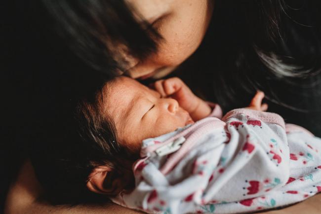 Close up of mother kissing her new baby during an in-home Perth Newborn Lifestyle photography session
