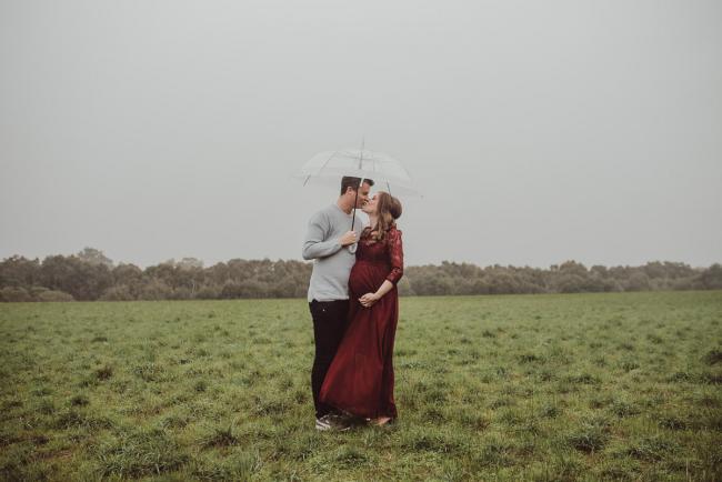 Perth-Maternity-Photographer-Perrys-Paddock-11-of-39 Pregnant couple kissing under an umbrella during a Perth maternity session at Perry's Paddock during rain
