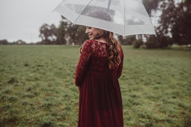 Perth-Maternity-Photographer-Perrys-Paddock-18-of-39 Pregnant lady looking over her shoulder under an umbrella during a Perth maternity session at Perry's Paddock during rain
