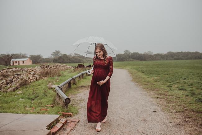 Perth-Maternity-Photographer-Perrys-Paddock-26-of-39 Pregnant lady walking along the path under an umbrella during a Perth maternity session at Perry's Paddock during rain