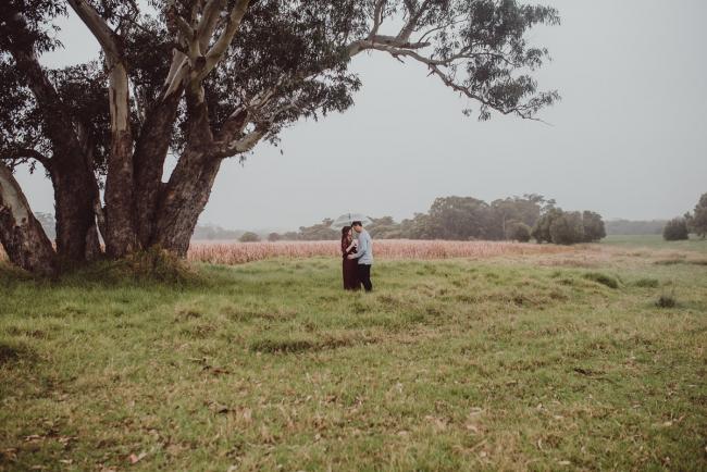 Perth-Maternity-Photographer-Perrys-Paddock-29-of-39 Pregnant couple standing under a tree during a Perth maternity session at Perry's Paddock during rain
