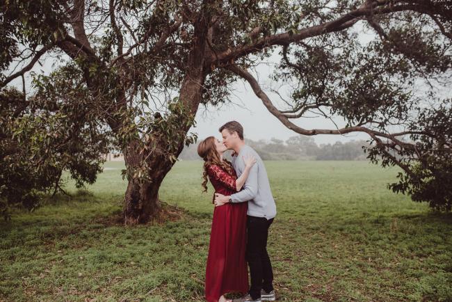 Perth-Maternity-Photographer-Perrys-Paddock-3-of-39 Couple kissing under a tree during a Perth maternity session at Perry's Paddock during rain