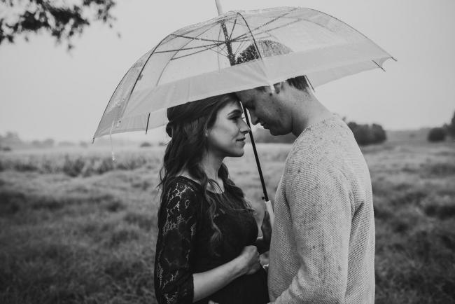 Perth-Maternity-Photographer-Perrys-Paddock-31-of-39 Black and white image of pregnant couple touching foreheads under an umbrella during a Perth maternity session at Perry's Paddock during rain