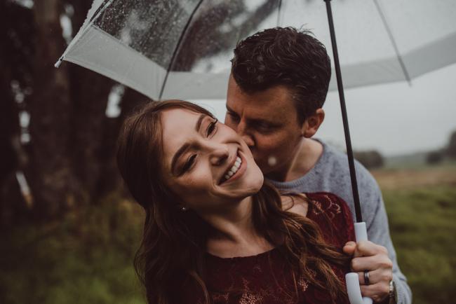 Perth-Maternity-Photographer-Perrys-Paddock-35-of-39 Man kissing his partner's neck during a Perth maternity session at Perry's Paddock during rain