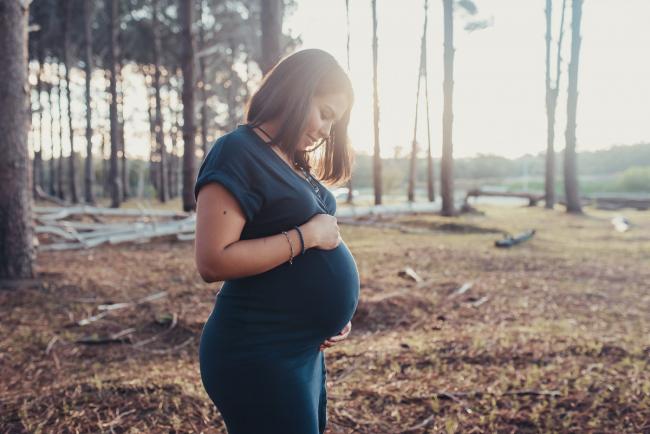 Perth-Maternity-Photographer-The-Pines-11-of-48 Pregnant woman looking down at her belly with Perth maternity photographer at The Pines