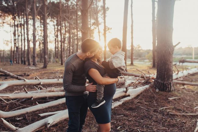 Perth-Maternity-Photographer-The-Pines-23-of-48 Father kissing neck of pregnant wife as she holds their son with Perth maternity photographer at The Pines