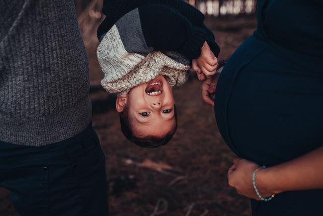 Perth-Maternity-Photographer-The-Pines-32-of-48 Little boy hanging upside down next to pregnant mum's tummy with Perth maternity photographer at The Pines