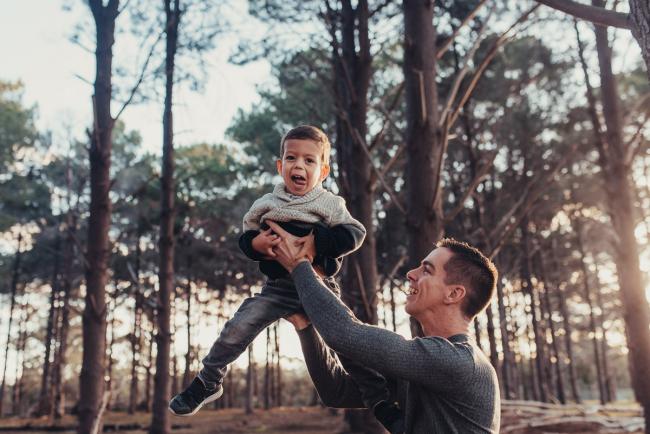 Father throwing son in the air with Perth family photographer at The Pines