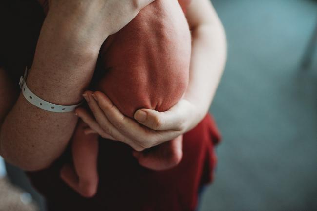 Naked baby bottom held by mother during a Perth Fresh 48 photography session at SJOG Mt Lawley