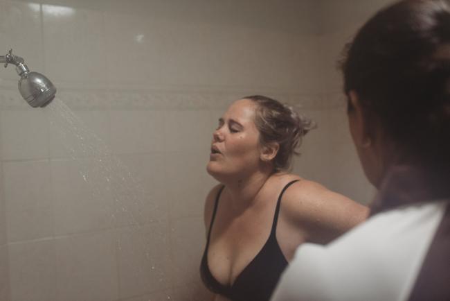 Pregnant woman breathing through a contraction in the shower with Perth birth photographer at the Family Birthing Centre