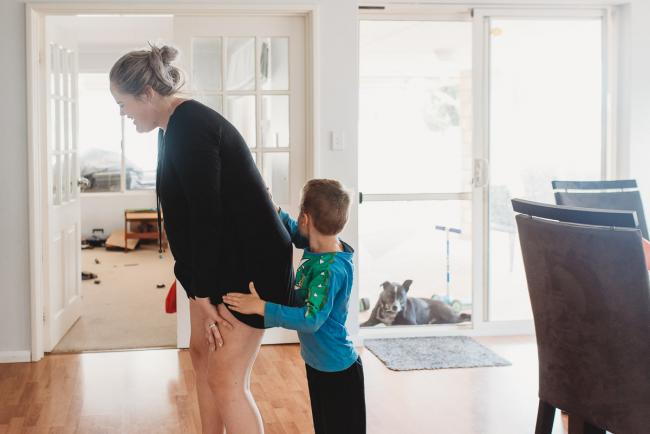 Little boy rubbing the back of his pregnant mother in labour with Perth Birth Photographer